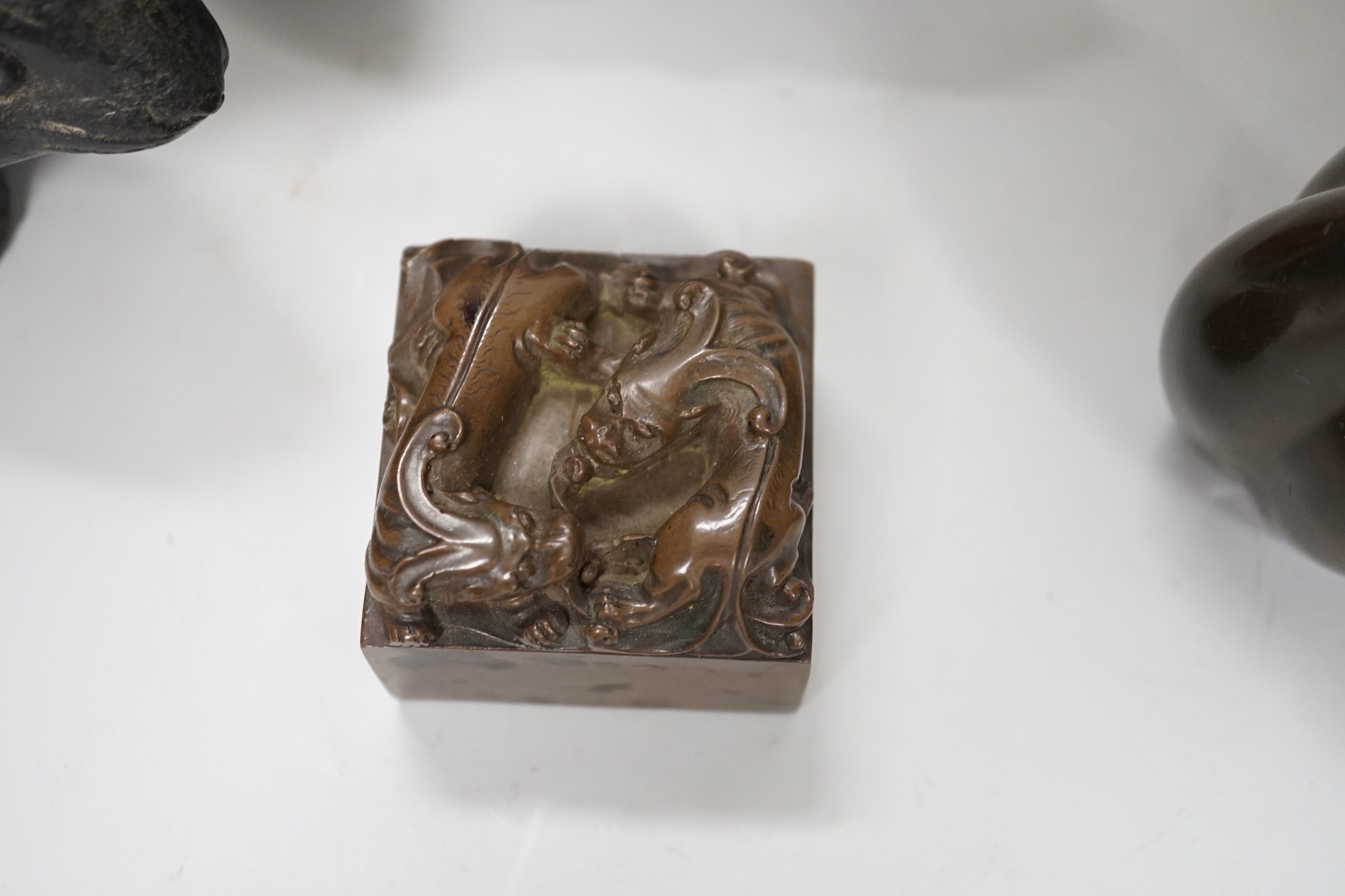 A pair of Chinese bronze models of rabbits, together with two vases and a dragon seal. Tallest 16cm